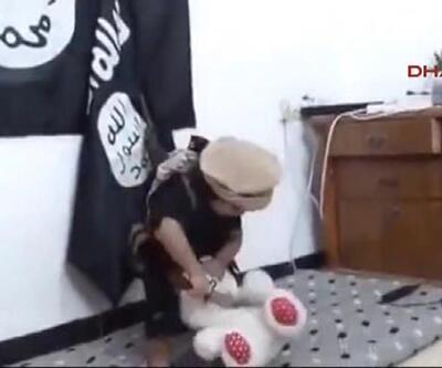 IŞİD bayrağı önünde oyuncağının kafasını kesiyor