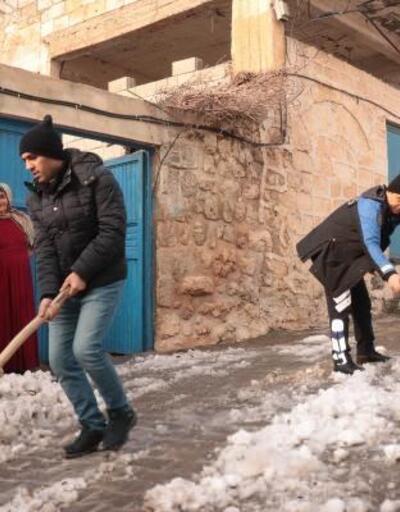 Polisler ve öğrenciler, yaşlı kadının evinin önündeki karı temizledi